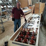 Bob Savage uncrates a collection of turnings, baubles, doodads, gewgaws, trinkets, knick-knacks and gimcracks  /Dobson Pipe Organ Builders